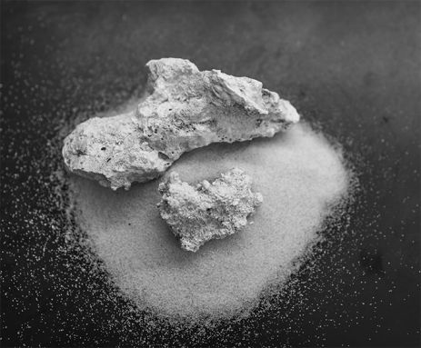 Two chunks of rock sit on a pile of sand. The rocks were created by zapping waterlogged sand with low voltage electricity.